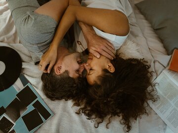 Eine Frau und ein Mann liegen im Bett und kuscheln | © GettyImages/Maskot