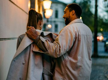 Person legt anderer Mantel über Schultern | © Getty Images/Janina Steinmetz