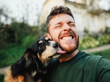 Person wird von Hund abgeschleckt | © Getty Images/Nazar Rybak