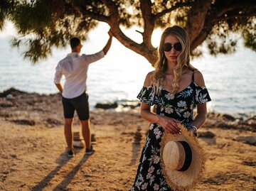 Paar steht im Urlaub am Strand und hat Streit. | © Getty Images / bojanstory