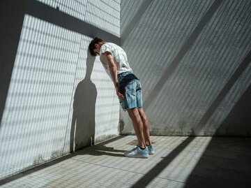 Mann lehnt verzweifelt mit dem Kopf gegen eine Wand | © Getty Images/Francesco Carta fotografo