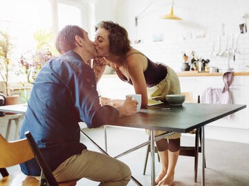 Paar küsst sich in der Küche | © Getty Images/Hinterhaus Productions