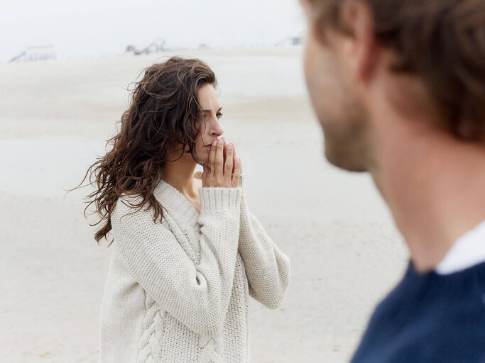 Frau und Mann stehen am Strand | © Getty Images/Oliver Rossi