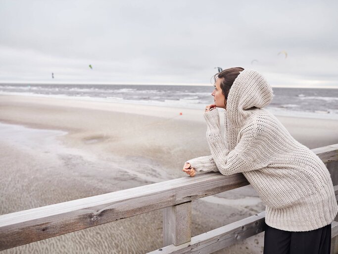 Frau ist am Strand und schaut nachdenklich | © Getty Images/Oliver Rossi