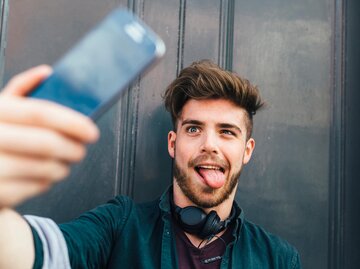 Mann macht Selfie mit rausgestreckter Zunge | © Getty Images/Westend61