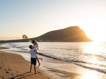 Glückliches Paar am Strand | © Getty Images/Andrea Comi