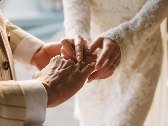 Braut und Bräutigam stecken sich Eheringe an | © Getty Images/Anna Blazhuk