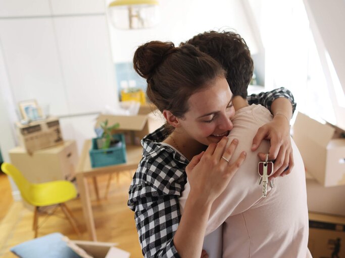 Frau und Mann umarmen sich während des Umzugs | © Getty Images/Catherine Delahaye