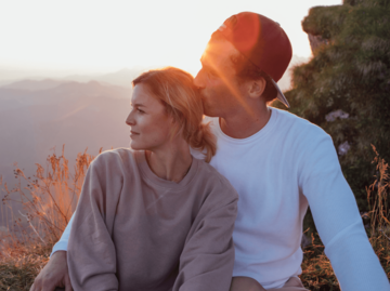 Frau und Mann sitzen auf Berg | © Getty Images/Westend61