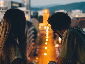 Mann und Frau schauen vom Dach aus in die Nacht | © Getty Images/Rafael Graf / EyeEm