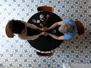Mann und Frau halten beim Date Händchen | © Getty Images/Halfdark