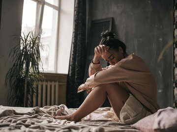 Frau sitzt traurig auf dem Bett | © Getty Images/Ol'ga Efimova / EyeEm