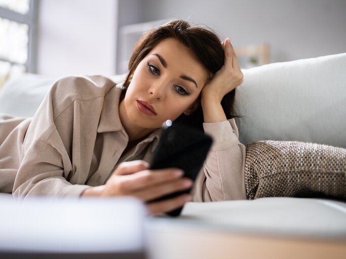 Frau schaut unglücklich auf ihr Handy | © shutterstock/Andrey_Popov