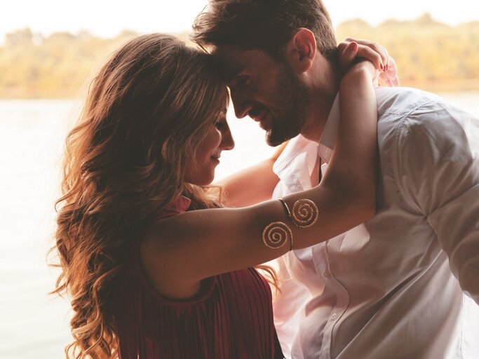Glückliches, junges Paar steht Stirn an Stirn einander verliebt gegenüber  | © shutterstock/patrisyu
