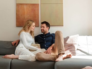 Frau und Mann unterhalten sich auf dem Sofa | © Getty Images/Lilly Bloom