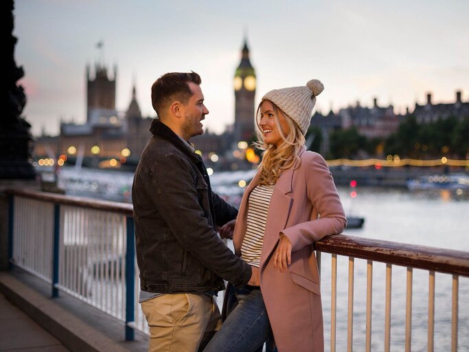 Frau und Mann bei Date lehnen an Geländer | © Getty Images/Nick Dolding