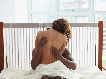 Frau sitzt auf Mann im Bett | © Getty Images/LWA/Dann Tardif