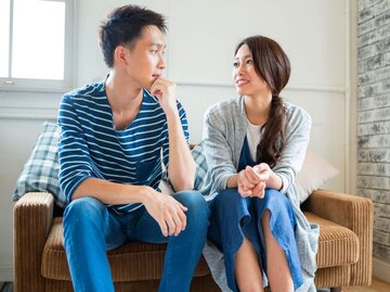 Mann und Frau unterhalten sich auf Couch. | © Getty Images/Indeed