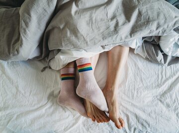 Füße im Bett haben Socken an | © Getty Images/FilippoBacci