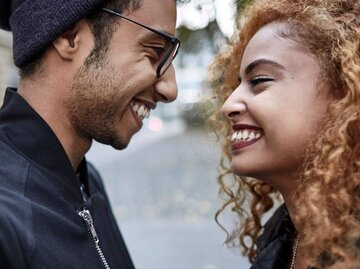 Frau und Mann lächeln sich an | © Getty Images/Oliver Rossi
