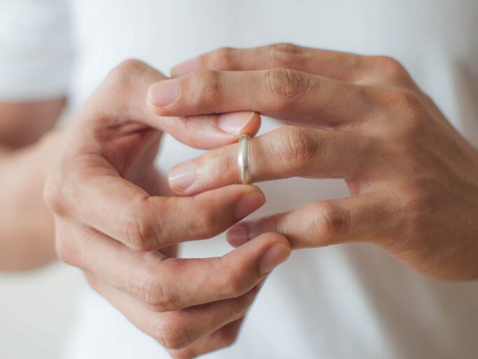 Mann zieht Ehering von Finger | © Getty Images/Karl Tapales