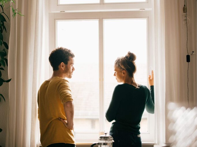 Frau und Mann unterhalten sich vorm Fenster | © Getty Images/Maskot