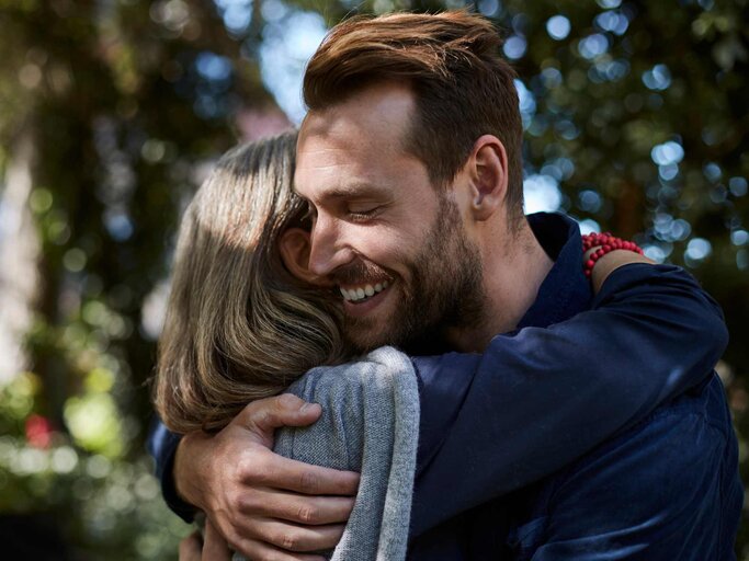 Junger Mann umarmt seine Mutter | © Getty Images/Oliver Rossi