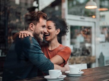 verliebtes Paar sitzt in einem Café und umarmt sich glücklich.  | © Getty Images / Westend61