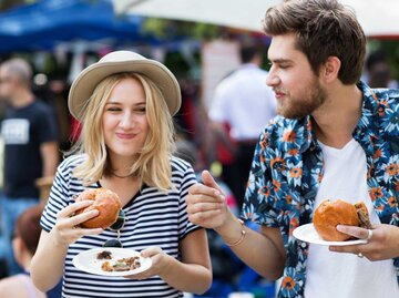 Frau und Mann essen freundschaftlich einen Burger | © Getty Images/Michael Heffernan