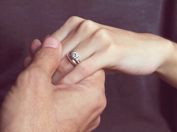 Eine Männerhand hält eine Frauenhand mit Verlobungsring | © GettyImages/Elizabeth Fernandez
