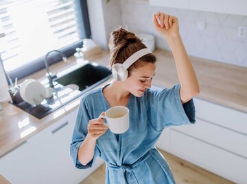 Junge Frau tanzt ausgelassen in der Küche | © Adobe Stock/Halfpoint