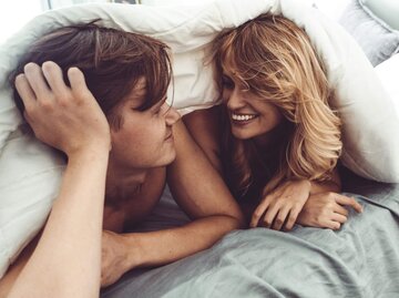 Frau und Mann unter Bettdecke | © Getty Images/franckreporter