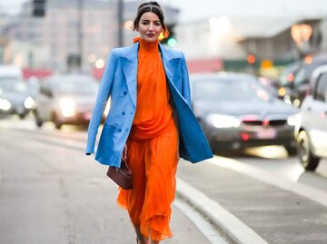 Alexandra Pereira in orangem Kleid und blauem Blazer | © Getty Images/Edward Berthelot 