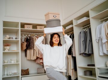 Frau balanciert Kartons auf ihrem Kopf | © Getty Images/Tatiana Meteleva