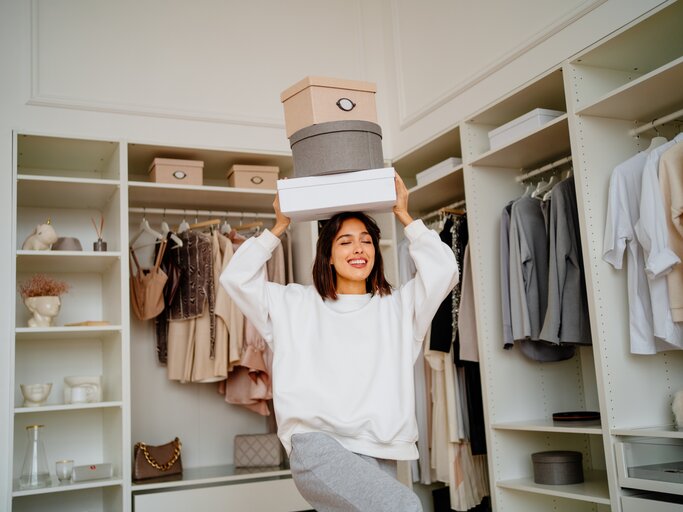 Frau balanciert Kartons auf ihrem Kopf | © Getty Images/Tatiana Meteleva