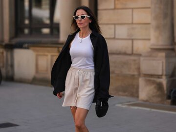 Frau mit beigen Shorts, weißem Tanktop und schwarzem oversized Hemd | © Getty Images/Jeremy Moeller 