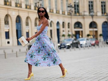 Model Emilie Joseph im blauen Kleid mit gelben High Heels | © Getty Images/Edward Berthelot 