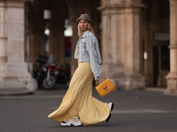Influencerin Karin Teigl in gelbem Kleid und klobigen, weißen Sneakers | © Getty Images/Jeremy Moeller