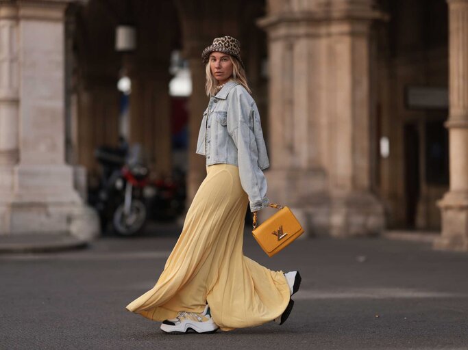 Influencerin Karin Teigl in gelbem Kleid und klobigen, weißen Sneakers | © Getty Images/Jeremy Moeller