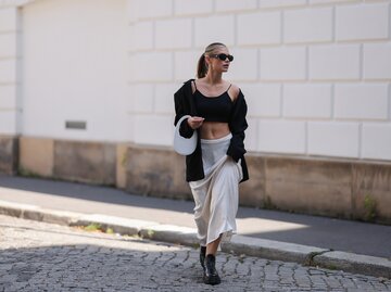 Eine Frau trägt einen weißen Maxirock und ein Outfit im Street Style | © GettyImages/Jeremy Moeller / Kontributor