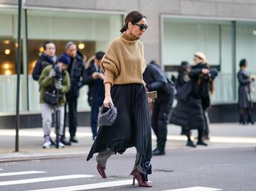 Streetstyle von Frau, die Plisseerock über Hose trägt | © Getty Images/Edward Berthelot