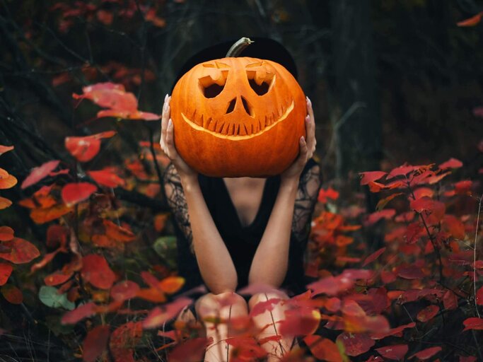 Person mit Halloween-Kürbis vor Kopf | © Getty Images/Maryna Terletska