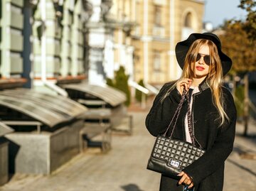 Porträt einer stilvollen blonden Frau mit Hut und Sonnenbrille | © GettyImages/pavlyukv