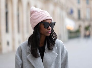 Person mit Sonnenbrille und rosa Mütze | © Getty Images/Edward Berthelot