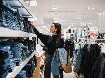 Hosen-Trend 2023 Frau sucht im Laden nach der passenden Hose | © Getty Images/lechatnoir 