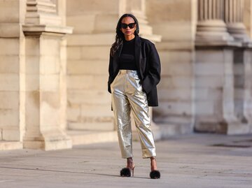 Streetstyle von Emilie Joseph in silberner Hose, schwarzem Top und schwarzem Blazer | © Getty Images/Edward Berthelot