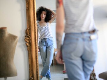 Frau vor dem Spiegel in Jeans | © Getty Images/zoranm
