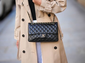 Close-up von schwarzer Chanel-Tasche, die zu beigem Trenchcoat getragen wird | © Getty Images/Edward Berthelot
