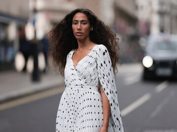 Streetstyle von Frau in weißem Kleid mit schwarzen Punkten | © Getty Images/Jeremy Moeller