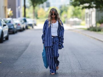 Streetstyle von Frau in blau-weiß gestreiftem Pyjama und weißem Tanktop | © Getty Images/Jeremy Moeller